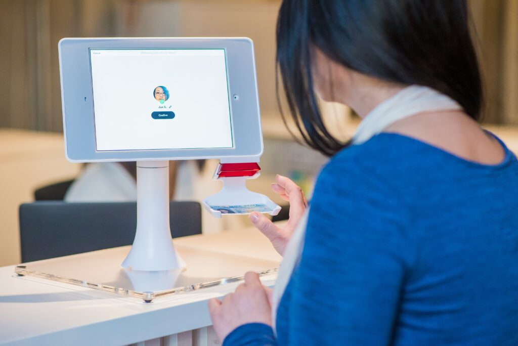 한 여성이 태블릿 단말기 앞에서 본인 인증을 진행하는 모습. 카드에서 얼굴로 결제 수단이 바뀌며 '신뢰 UX'가 중요해진 시대를 상징합니다.